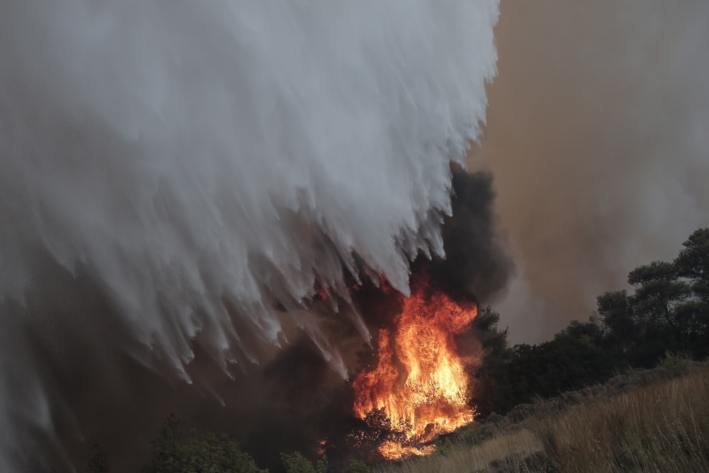 El fuego quema árboles durante un incendio forestal en la aldea de Palagia, al norte de Grecia.  / EFE