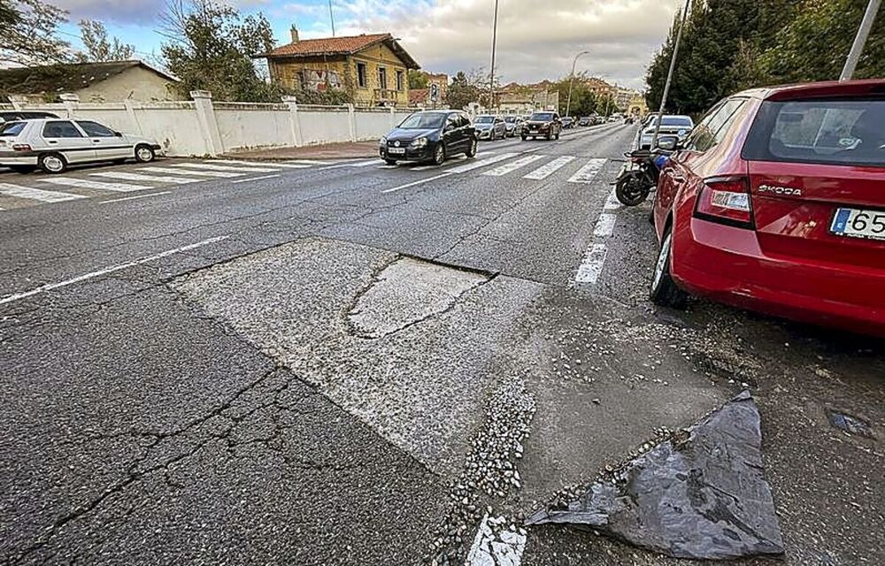 Tramo de la carretera de San Rafael en el acceso al Polígono de El Cerro por la calle Guadarrama, donde permanecen restos de un bacheo antiguo.