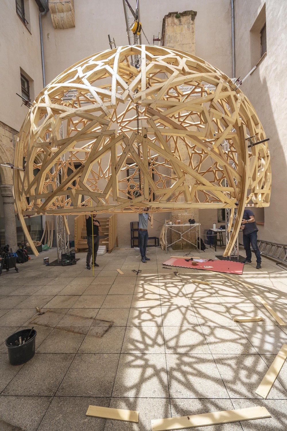 La cúpula de madera se está instalando en el patio renacentista del antiguo convento de Santa Cruz la Real de Segovia, sede actual de IE University, donde se ubicará de manera provisional..