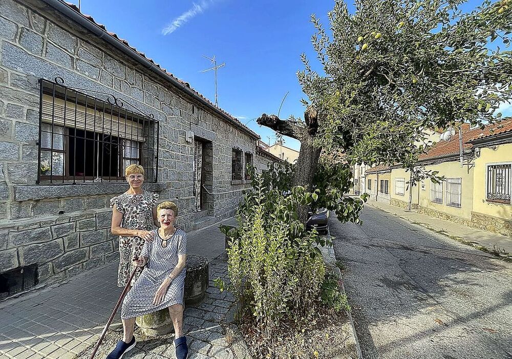 Carmen Pantoja, sentada junto a su hija Mercedes al lado del manzano que plantó el abuelo Julián junto a su casa.