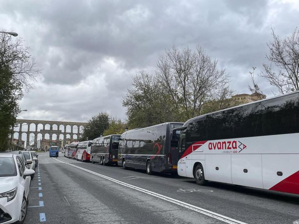 Fila de autobuses fletados por operadores turísticos este mediodía en la avenida Vía Roma de Segovia. 